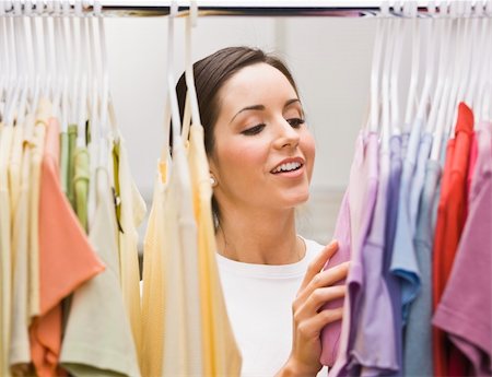 simsearch:400-06517383,k - An attractive young female looking through a clothing closet.  She is smiling.  Horizontally framed photo. Fotografie stock - Microstock e Abbonamento, Codice: 400-04120587