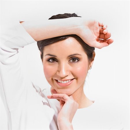 exfoliate teen face - An attractive female posing.  She is framing her face with her hands and is smiling directly at the camera.  Square framed shot. Stock Photo - Budget Royalty-Free & Subscription, Code: 400-04120592