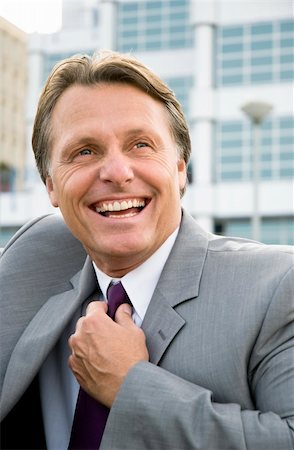 colour portrait of a happy smiling businessman adjusting his tie. Foto de stock - Super Valor sin royalties y Suscripción, Código: 400-04120722