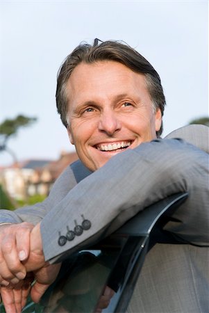 A colour portrait of a handsome smiling forties businessman leaning on the door of his car and looking to the side. Foto de stock - Super Valor sin royalties y Suscripción, Código: 400-04120734