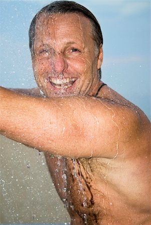 A colour portrait of a happy smiling forties man washing and having fun under the shower. Photographie de stock - Aubaine LD & Abonnement, Code: 400-04120881