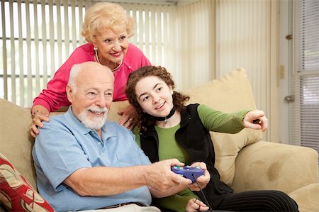 Senior couple playing video games with their teenage granddaughter. Stock Photo - Budget Royalty-Free & Subscription, Code: 400-04120995