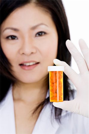 empty doctors uniform - Asian doctor holding a bottle of pills Stock Photo - Budget Royalty-Free & Subscription, Code: 400-04121331