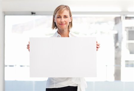 simsearch:400-04648812,k - Mature woman showing a big business card in office Stock Photo - Budget Royalty-Free & Subscription, Code: 400-04121396