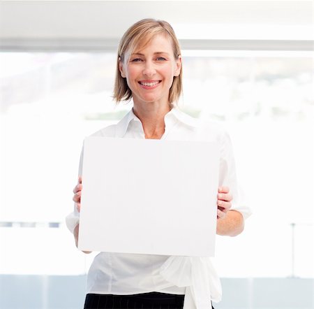 simsearch:400-04648812,k - Smiling woman showing a big business card in office Stock Photo - Budget Royalty-Free & Subscription, Code: 400-04121399