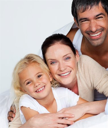 simsearch:400-04192370,k - Happy parents and daughter on bed smiling at the camera Fotografie stock - Microstock e Abbonamento, Codice: 400-04121402