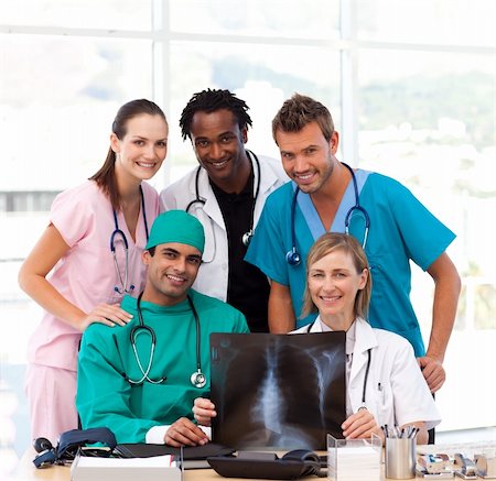 simsearch:400-04178933,k - Medical team examining an X-ray in hospital and smiling at the camera Stock Photo - Budget Royalty-Free & Subscription, Code: 400-04121415