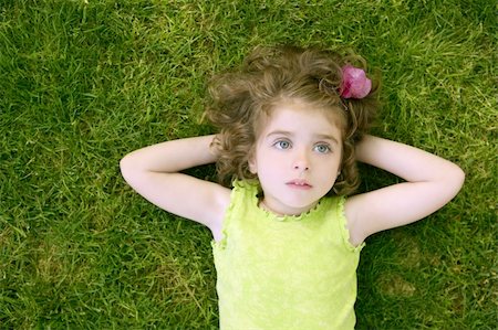 simsearch:400-05248187,k - Beautiful little toddler girl happy lying on the green grass Photographie de stock - Aubaine LD & Abonnement, Code: 400-04122804