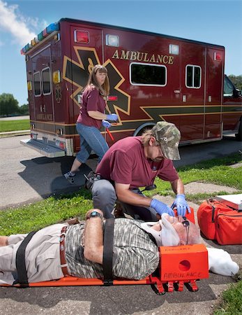 An EMT positions a patient with suspected neck / back injuries on a back board.  The patient is also wearing a cervical neck collar (C-collar). Stock Photo - Budget Royalty-Free & Subscription, Code: 400-04122982