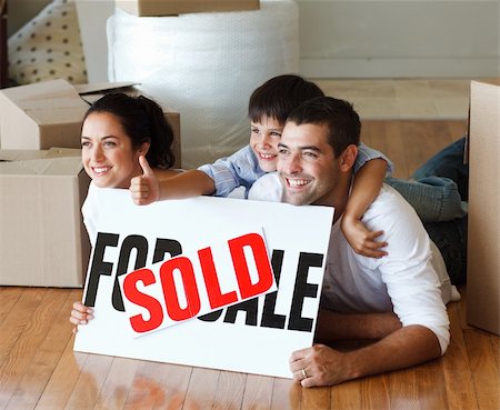 family with sold sign - Happy family lying on the floor after buying new house with thumbs up Stock Photo - Budget Royalty-Free & Subscription, Code: 400-04123076