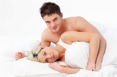 simsearch:400-04326193,k - Young couple lying together on bed and smiling at the camera Stock Photo - Budget Royalty-Free & Subscription, Code: 400-04123171