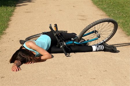 Female bike rider takes a tumble and lying unconscious on the road Stock Photo - Budget Royalty-Free & Subscription, Code: 400-04123719