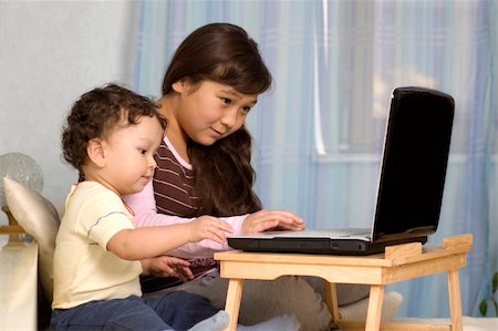 The elder sister and the junior brother play on a computer. Stock Photo - Budget Royalty-Free & Subscription, Code: 400-04136679