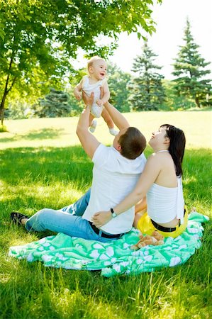 simsearch:400-06062677,k - Heureuses parents jouant avec leur bébé dans le parc Photographie de stock - Aubaine LD & Abonnement, Code: 400-04136789