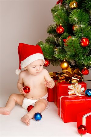 simsearch:400-06557484,k - Baby Boy in Nikolausmütze sitzen neben präsentiert Stockbilder - Microstock & Abonnement, Bildnummer: 400-04136822