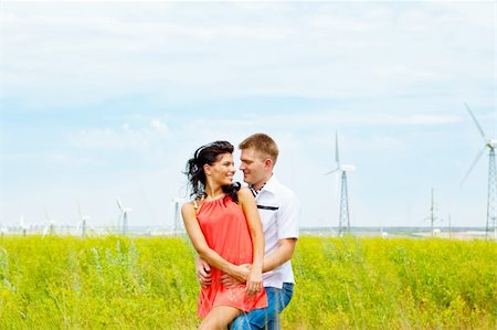 Loving couple standing in the field with wind turbines Stock Photo - Budget Royalty-Free & Subscription, Code: 400-04136841