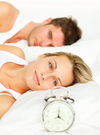 simsearch:400-04287303,k - Attractive woman lying with her boyfriend looking at the alarm clock Stock Photo - Budget Royalty-Free & Subscription, Code: 400-04138170
