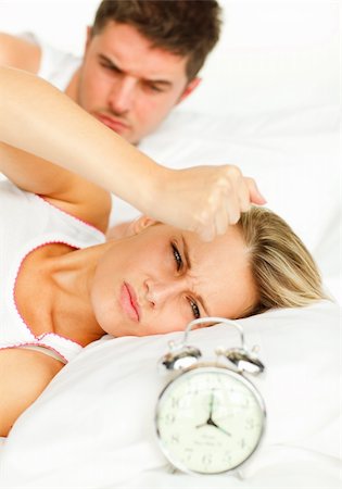 simsearch:400-04287303,k - Attractive man and angry woman in bed looking at the alarm clock going off Stock Photo - Budget Royalty-Free & Subscription, Code: 400-04138172