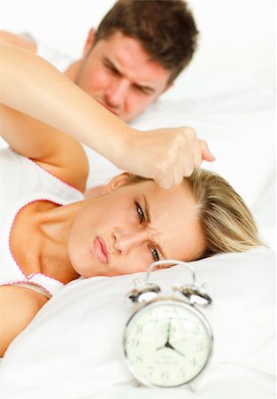 simsearch:400-04287303,k - Attractive man and angry woman in bed looking at the alarm clock going off Stock Photo - Budget Royalty-Free & Subscription, Code: 400-04138173