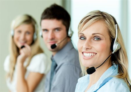 Young businesspeople smiling at the camera with headsets in an office Stock Photo - Budget Royalty-Free & Subscription, Code: 400-04138247