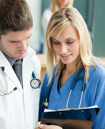 Young doctors reading a report in hospital reception Stock Photo - Budget Royalty-Free & Subscription, Code: 400-04138318