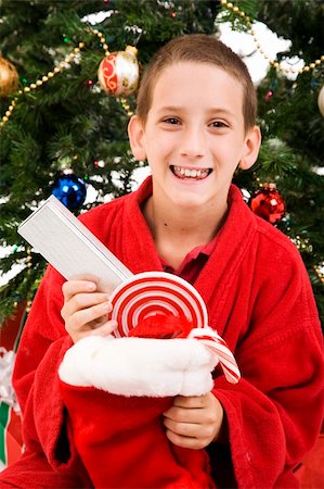 Adorable little boy opens his Christmas stocking. Stock Photo - Budget Royalty-Free & Subscription, Code: 400-04138387