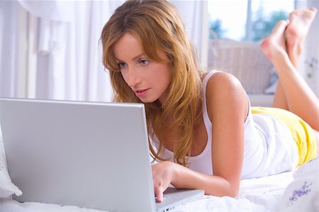 Young woman working with her laptop in bed Stock Photo - Budget Royalty-Free & Subscription, Code: 400-04138918