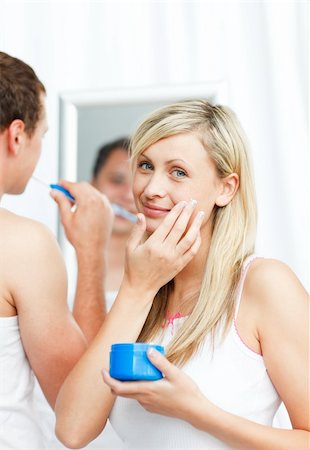 face cream male - Beautiful woman putting cream on her face with her boyfriend in bathroom Stock Photo - Budget Royalty-Free & Subscription, Code: 400-04139555