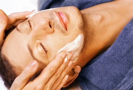 Middle-age man is getting cream mask and massage on his face Fotografie stock - Microstock e Abbonamento, Codice: 400-04130013