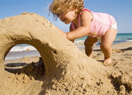 Little girl on the beach making a sand castle Stock Photo - Budget Royalty-Free & Subscription, Code: 400-04130179