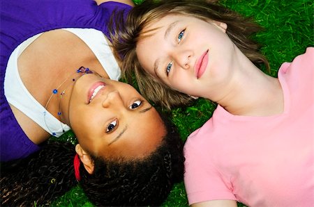 simsearch:400-05372366,k - Two teenage girls laying on grass looking up Foto de stock - Royalty-Free Super Valor e Assinatura, Número: 400-04130249