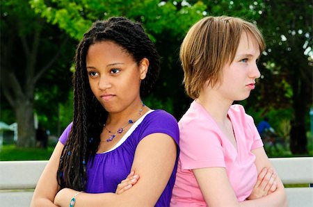 Two unhappy teenage girls sitting on bench Stock Photo - Budget Royalty-Free & Subscription, Code: 400-04130254