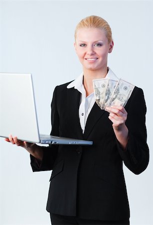 simsearch:400-04130596,k - Young attractive woman holding dollars and a laptop Stock Photo - Budget Royalty-Free & Subscription, Code: 400-04130593