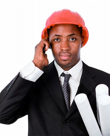 Serious ethnic architect holding blueprints and talking on the phone Stock Photo - Budget Royalty-Free & Subscription, Code: 400-04130680