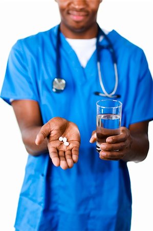 simsearch:400-04130714,k - Gros plan d'un docteur Young afro-américaine détenant des pilules et verre d'eau devant la caméra Photographie de stock - Aubaine LD & Abonnement, Code: 400-04130713