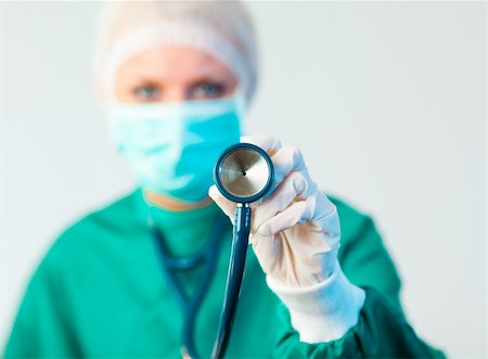 simsearch:400-06634198,k - Young Female Suregon holding stethoscope outwards with focus on the stethoscope Stock Photo - Budget Royalty-Free & Subscription, Code: 400-04130925