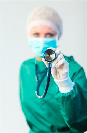 simsearch:400-06634198,k - Young Female Suregon holding stethoscope outwards with focus on the stethoscope Stock Photo - Budget Royalty-Free & Subscription, Code: 400-04130926