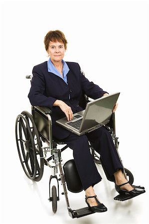 Serious buisinesswoman in a wheelchair working on her laptop computer.  Isolated on white. Stock Photo - Budget Royalty-Free & Subscription, Code: 400-04131208