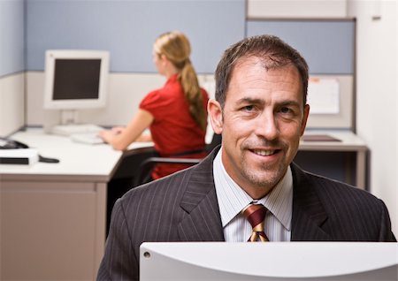 simsearch:400-04129016,k - Businessman sitting at desk smiling Stock Photo - Budget Royalty-Free & Subscription, Code: 400-04132827