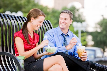 Businessman and businesswoman taking a lunch break outside on a park bench Stock Photo - Budget Royalty-Free & Subscription, Code: 400-04133499
