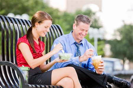 Business man and woman sitting on a bench outside and eating lunch Stock Photo - Budget Royalty-Free & Subscription, Code: 400-04133500