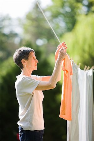 Older woman hanging her laundry outside Stock Photo - Budget Royalty-Free & Subscription, Code: 400-04133526
