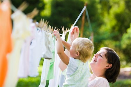Clothes drying on a clothes line outside with a baby touching the clothes in the back ground Foto de stock - Super Valor sin royalties y Suscripción, Código: 400-04133539