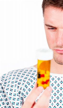doctor feeling - Young patient with a coat and holding a bottle of pills Stock Photo - Budget Royalty-Free & Subscription, Code: 400-04133578