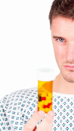 doctor feeling - Young patient with a coat and holding a bottle of pills Stock Photo - Budget Royalty-Free & Subscription, Code: 400-04133581