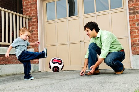 dad with toddler playing game - Father teaching son to play soccer on driveway Stock Photo - Budget Royalty-Free & Subscription, Code: 400-04133782