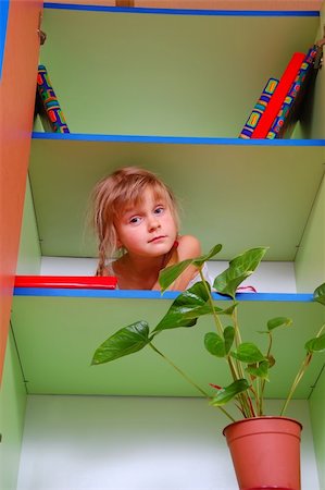 cute child peeking out of the bookcase Stock Photo - Budget Royalty-Free & Subscription, Code: 400-04144214