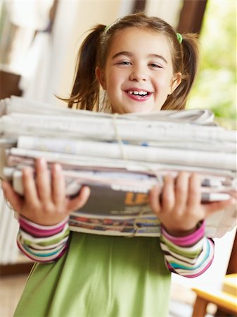 family recycling - girl carrying newspapers for recycling, looking at camera Stock Photo - Budget Royalty-Free & Subscription, Code: 400-04146963