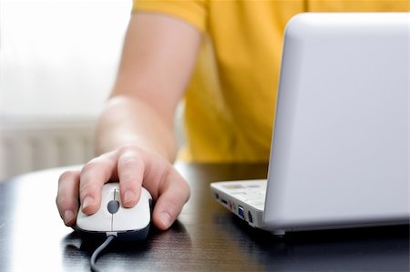 Man in yellow shirt with his right hand on the mouse (shallow DOF) Stock Photo - Budget Royalty-Free & Subscription, Code: 400-04148096