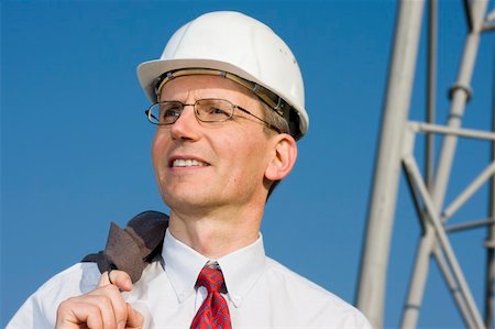 Smiling engineer with white hardhat on construction site Stock Photo - Budget Royalty-Free & Subscription, Code: 400-04140825